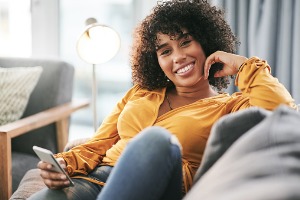 Woman Sitting on Couch with Mobile Phone 